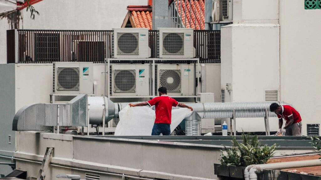 a couple of men standing on top of a roof